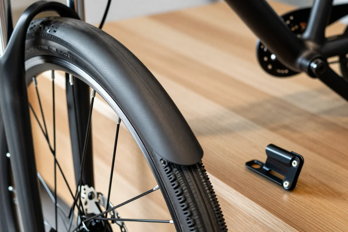 Porównanie pełnych błotników i skrzydełek rowerowych na drewnianym tle.