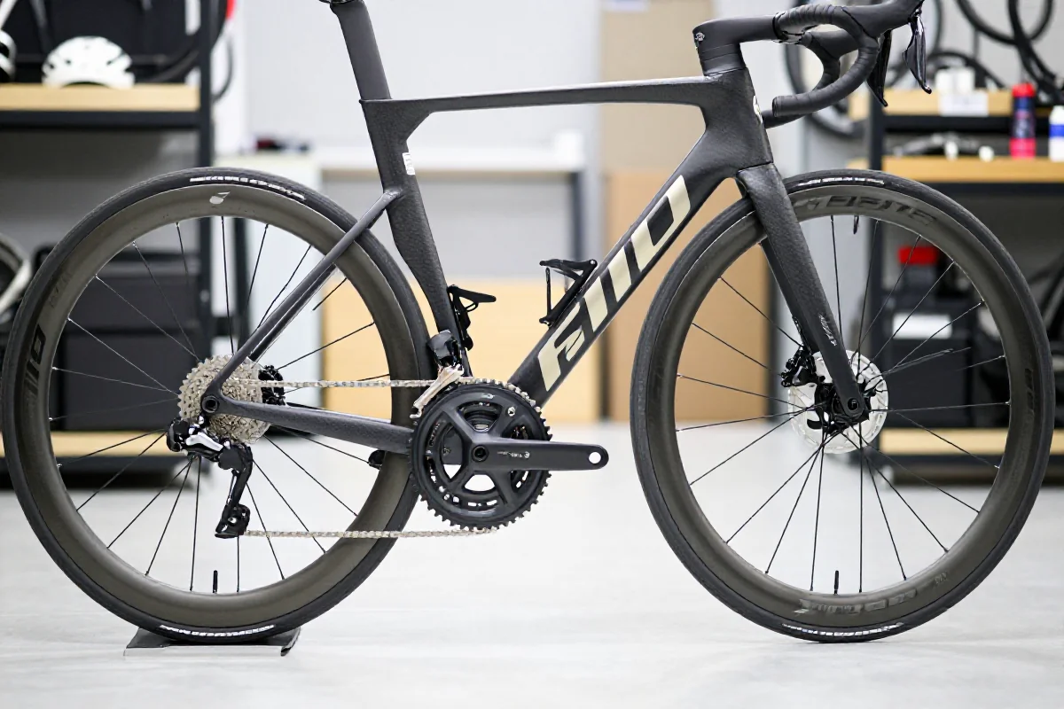 Zbliżenie na rower szosowy przed wyścigiem, pokazujące detale techniczne i stan komponentów.