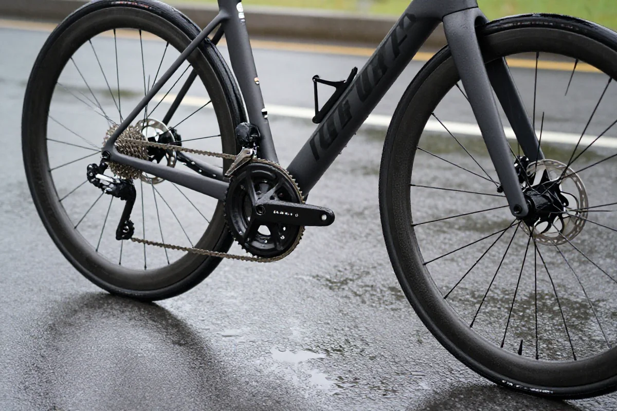 Rower szosowy na mokrej nawierzchni, podkreślający bezpieczeństwo w zmiennych warunkach.