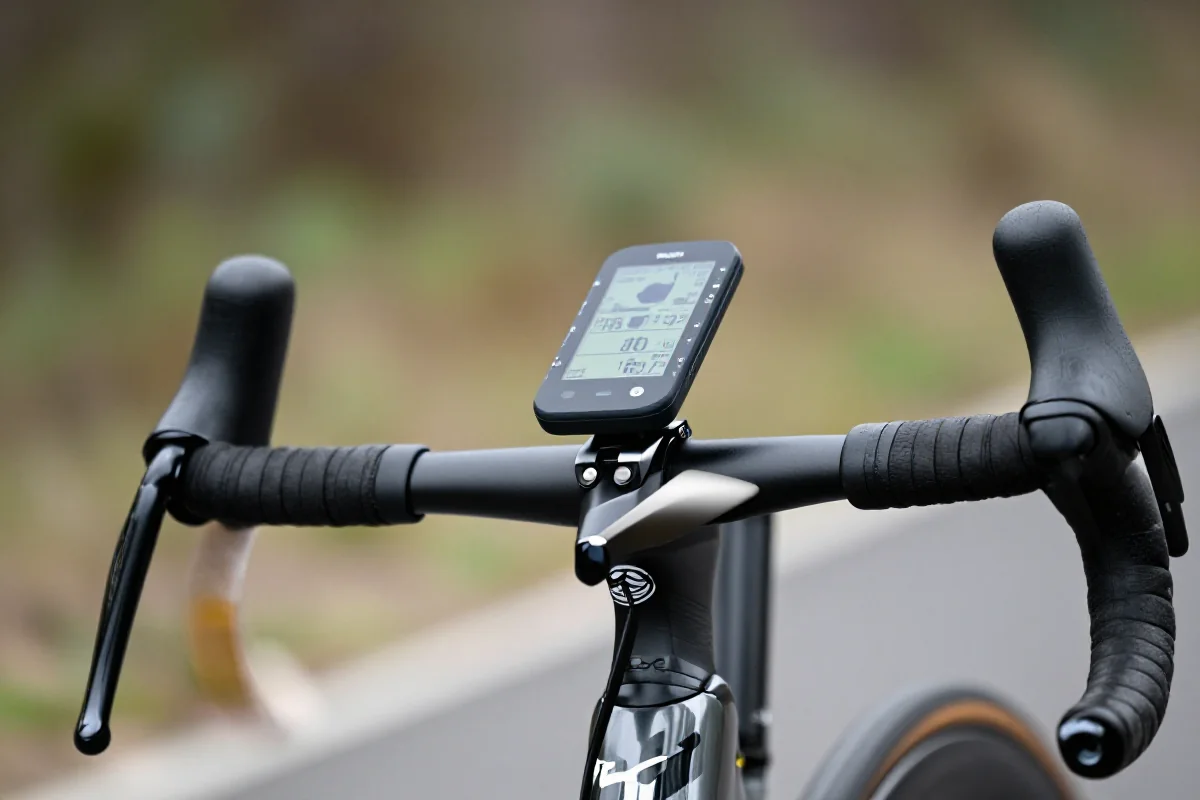 Nowoczesny komputer rowerowy na kierownicy roweru szosowego z danymi treningowymi.