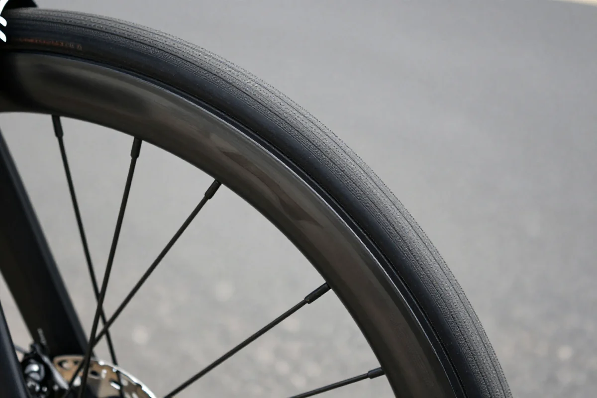 Opona rowerowa na asfalcie, podkreślająca opór toczenia i technologie opon.