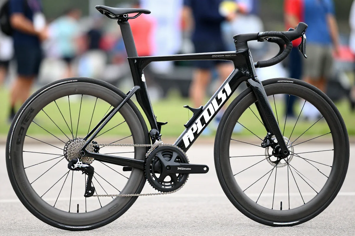 Szczegóły roweru szosowego z karbonową ramą i lekkimi kołami.