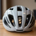Kask rowerowy na stole, eksponujący cechy bezpieczeństwa i nowoczesny design.