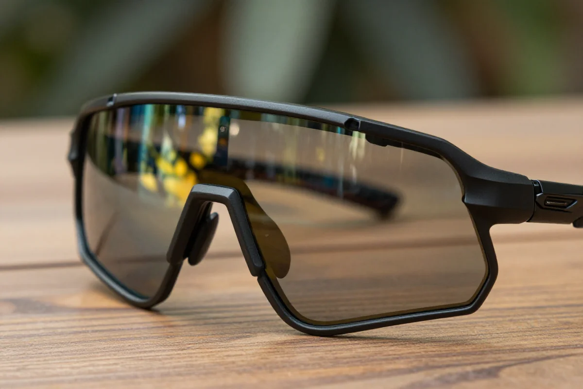 Okulary kolarskie z soczewkami fotochromowymi na drewnianym stole.