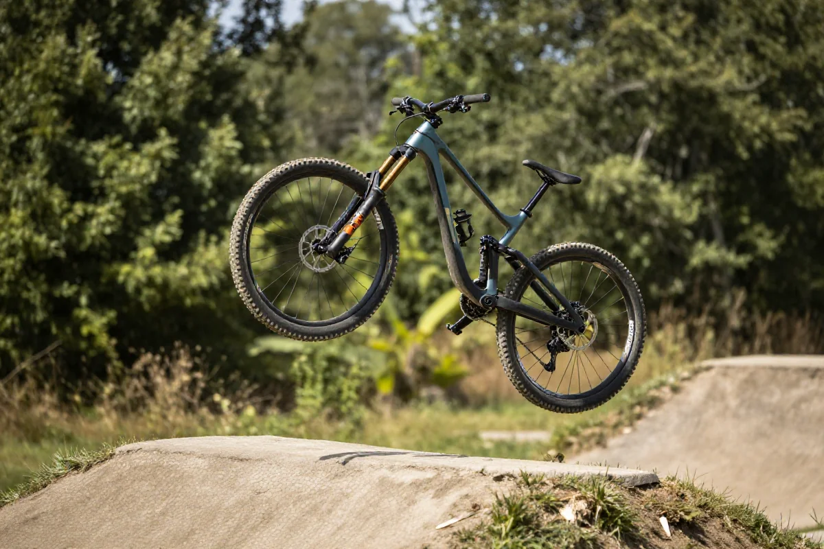 Rower górski skaczący nad przeszkodą typu tabletop w parku rowerowym.