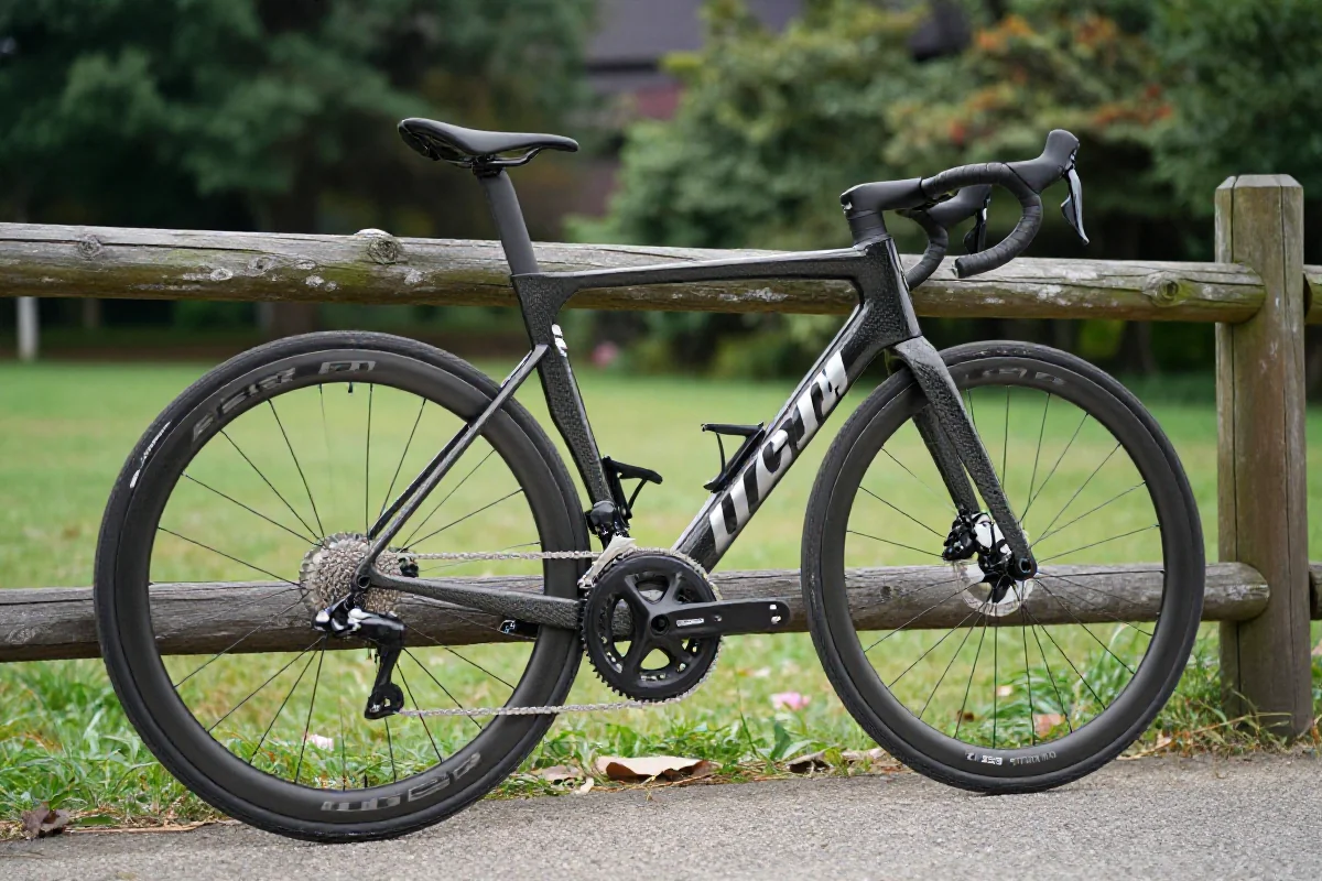 Nowoczesny rower szosowy przy drewnianym ogrodzeniu w parku.